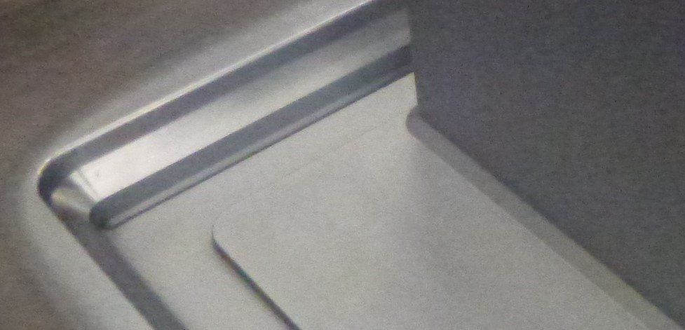 Een close-up van een roestvrijstalen wasbak in een badkamer.