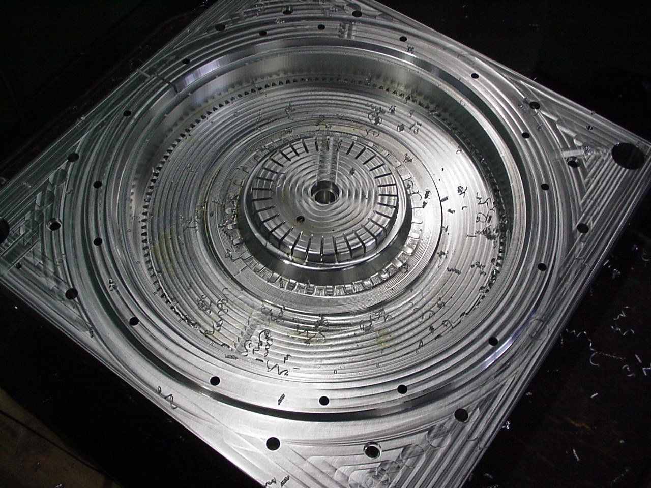 Een metalen mal staat op een houten tafel.