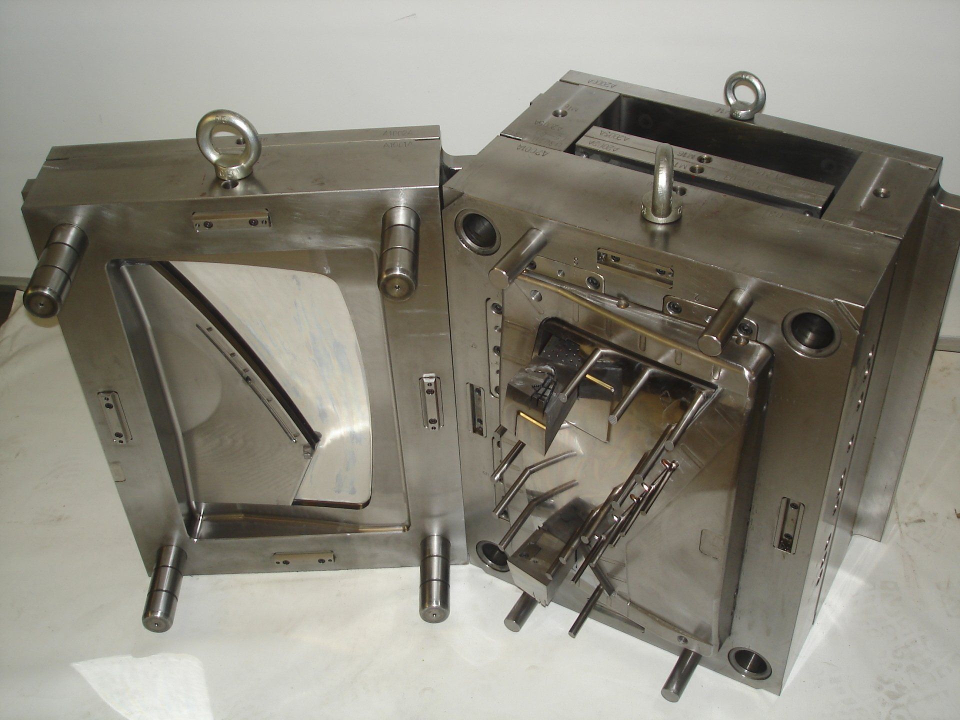 Twee metalen mallen staan ​​op elkaar op een tafel.