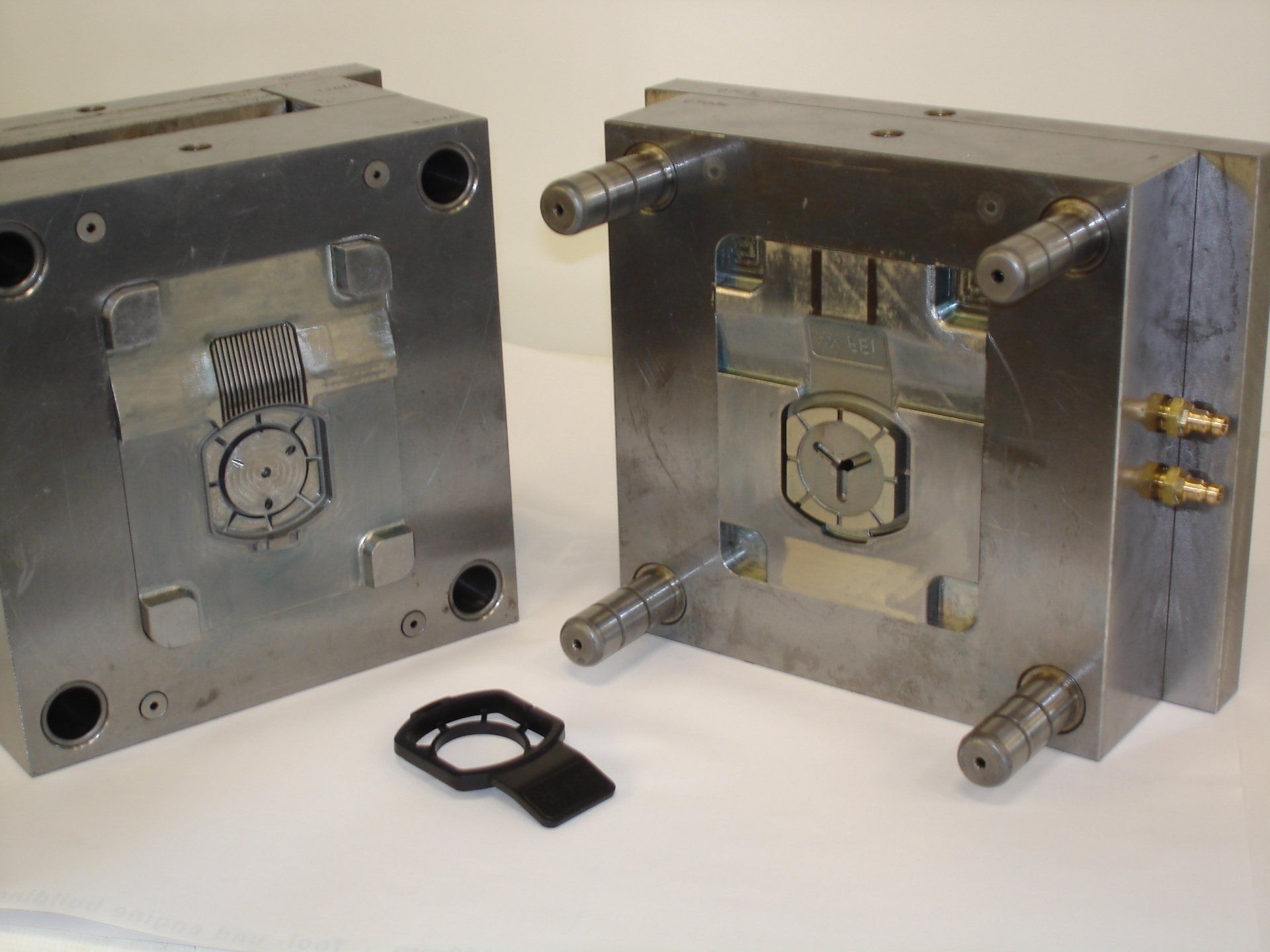 Twee metalen mallen staan ​​op een tafel en op één ervan staat een klok