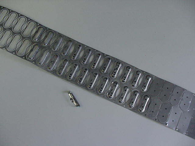 Een stuk metaal met gaten erin ligt op een tafel