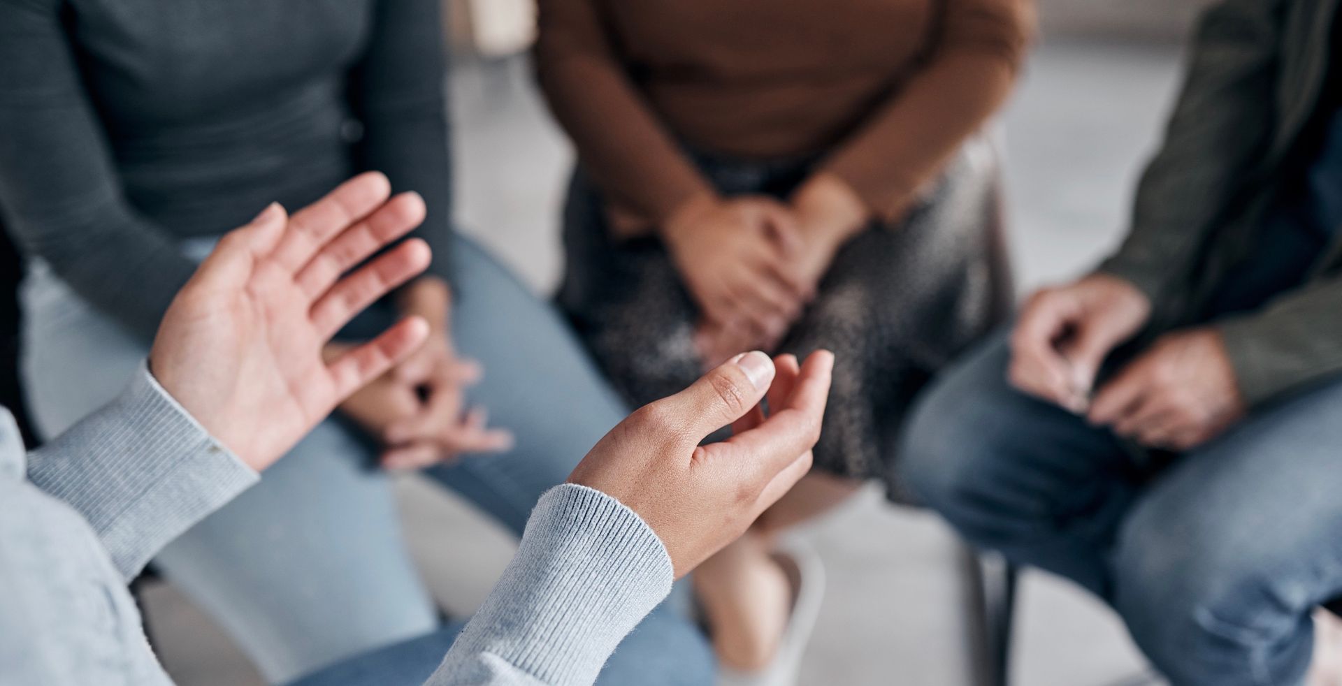 A group of people are sitting in a circle talking to each other.