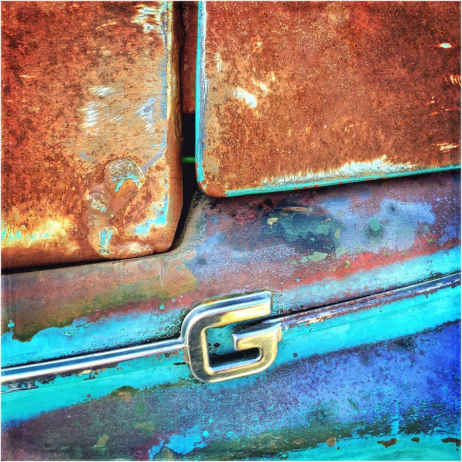 A rusty car with the letter g on it