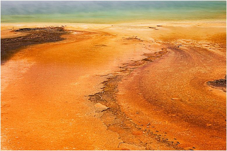 An aerial view of a sandy beach with a river running through it.