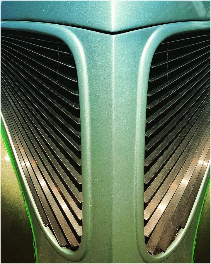 A close up of the front of a green car