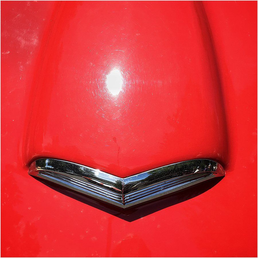 A close up of a red car with a chrome trim