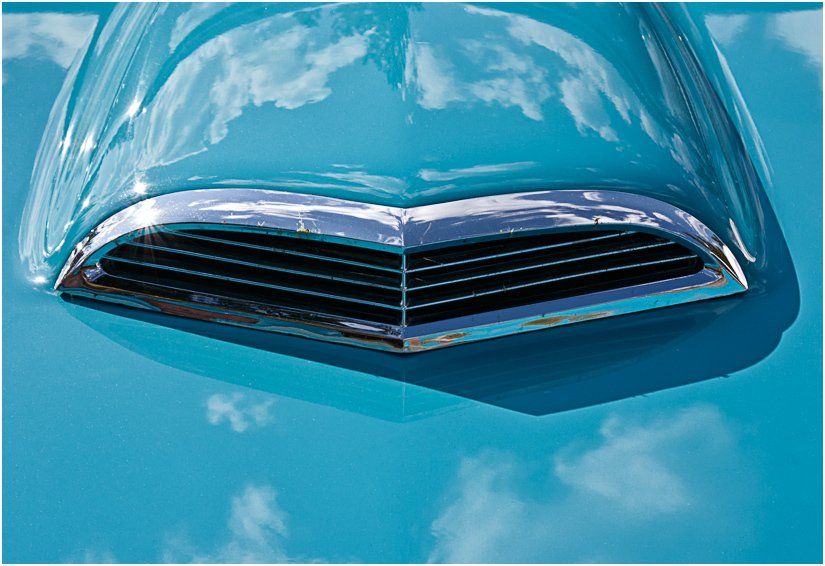 A close up of the hood of a blue car