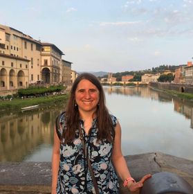 Dr. Carolina Franco in a floral shirt stands in front of a river