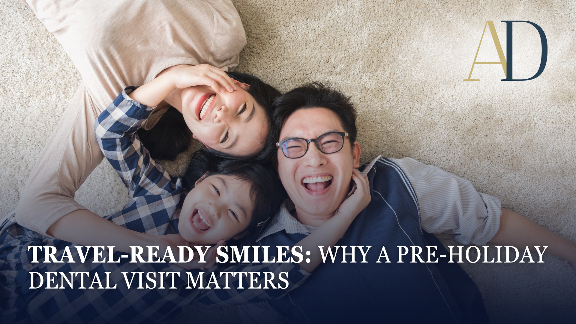 A family is smiling while laying on the floor.