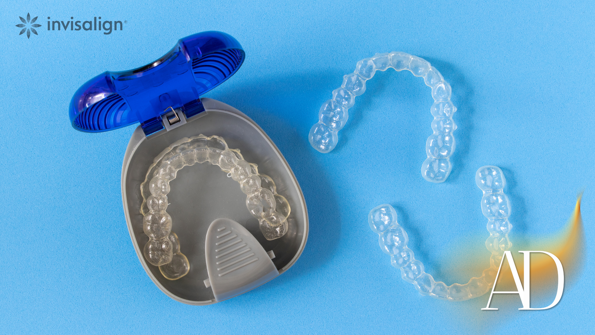 A pair of invisalign aligners sitting on top of a blue surface.