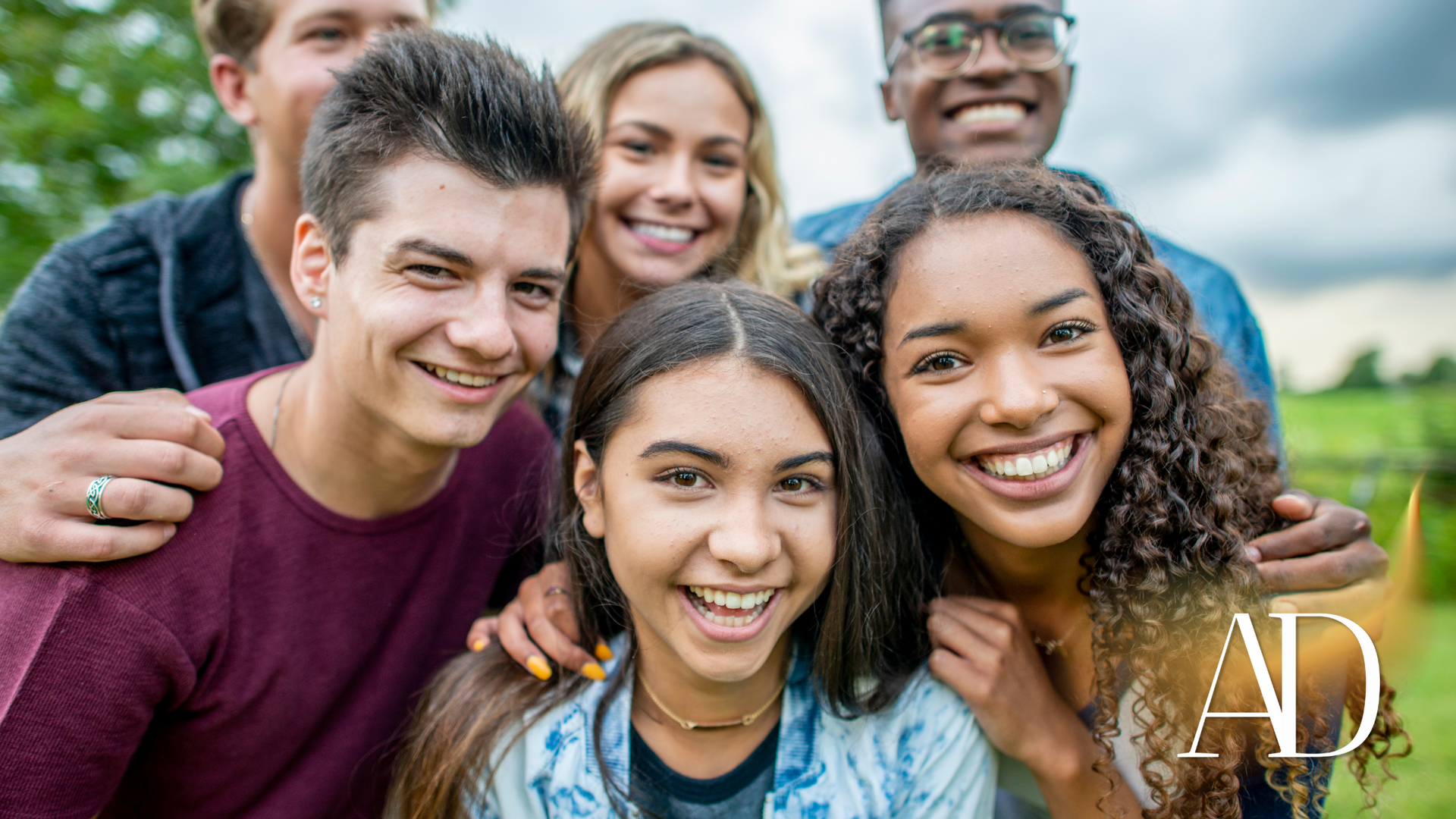 A group of young people are posing for a picture together and smiling.