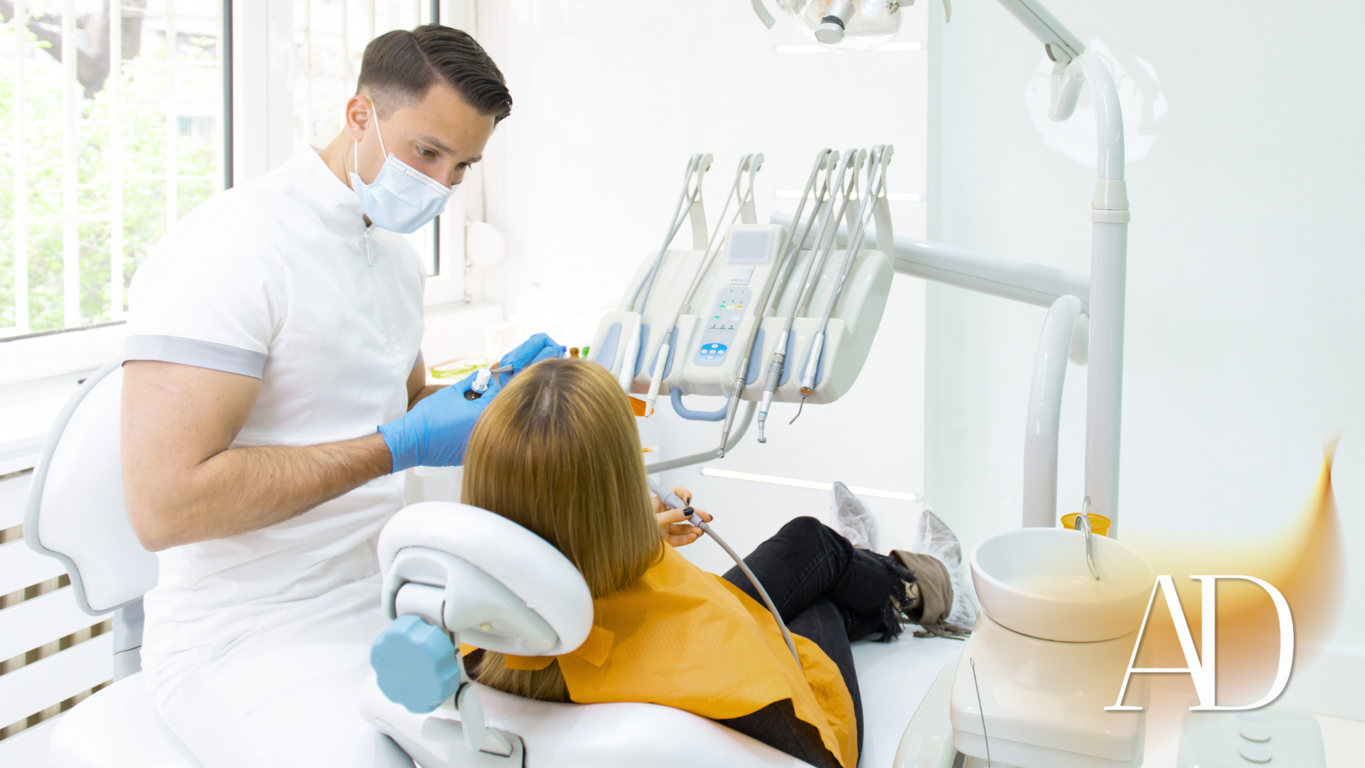 A dentist is examining a patient 's teeth in a dental office.