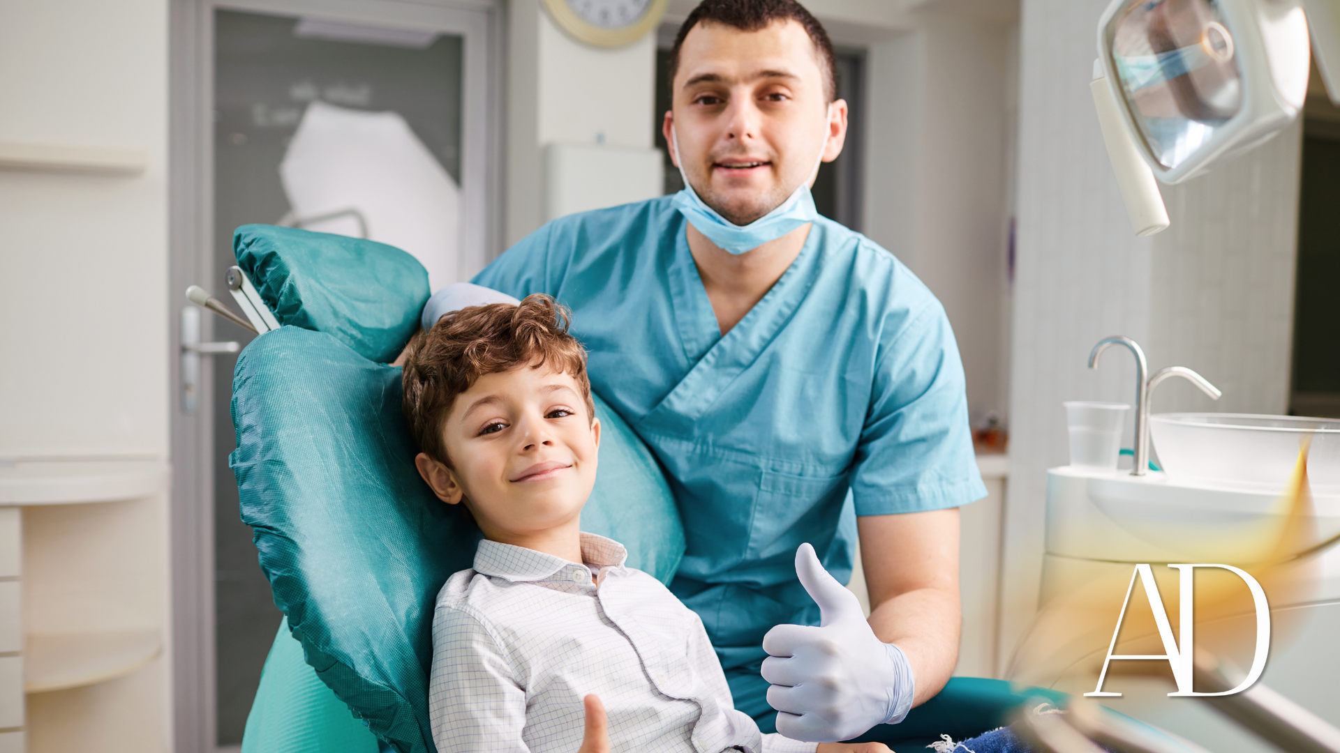 A young boy is sitting in a dental chair with a dentist.