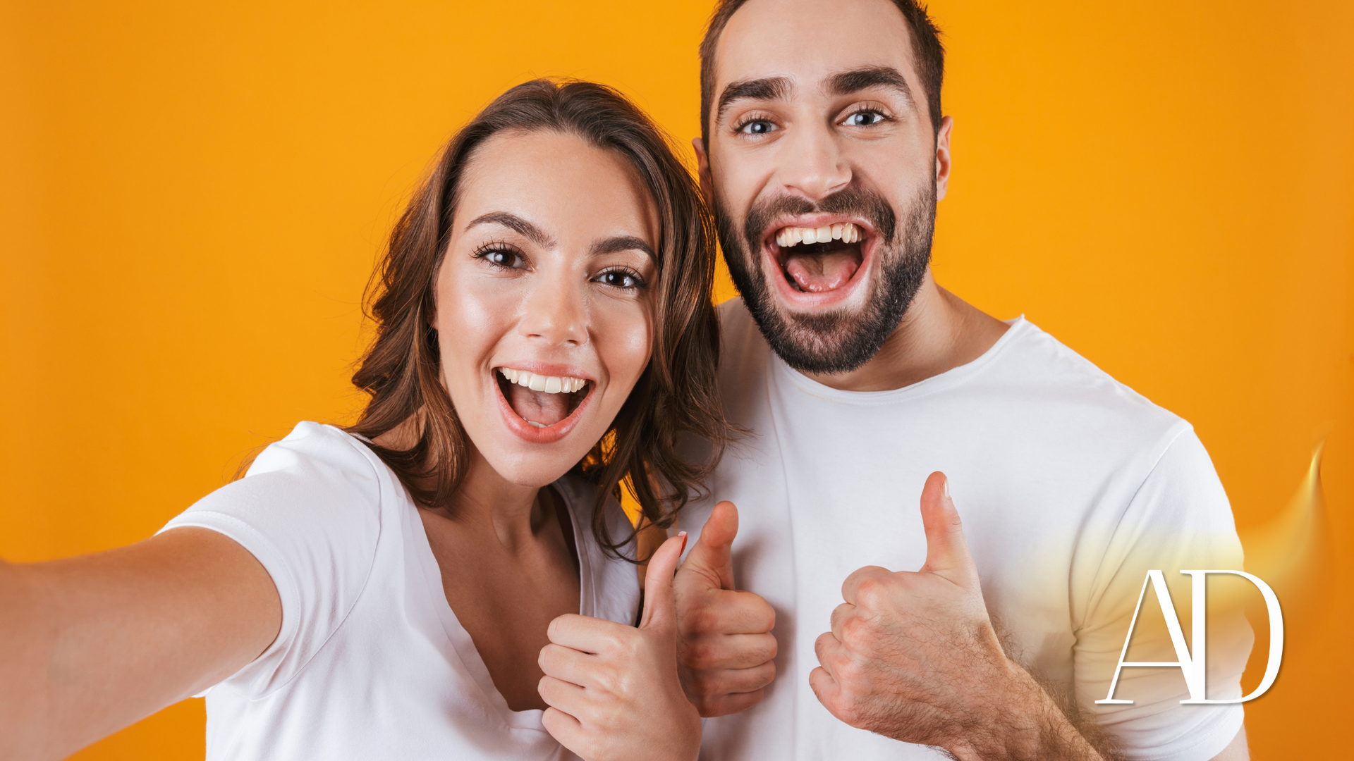 A man and a woman are taking a selfie and giving a thumbs up.