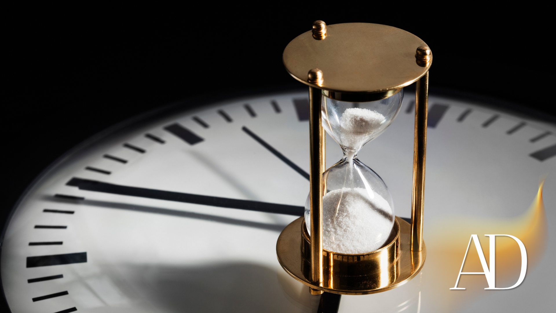 Hourglass with white sand on a clock face, representing the passage of time.