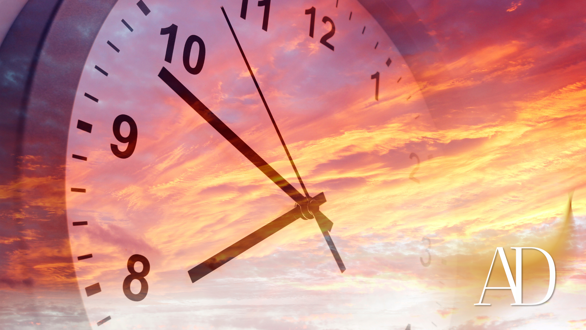 Clock overlayed on a vibrant sunset sky, hands pointing to ten past seven.