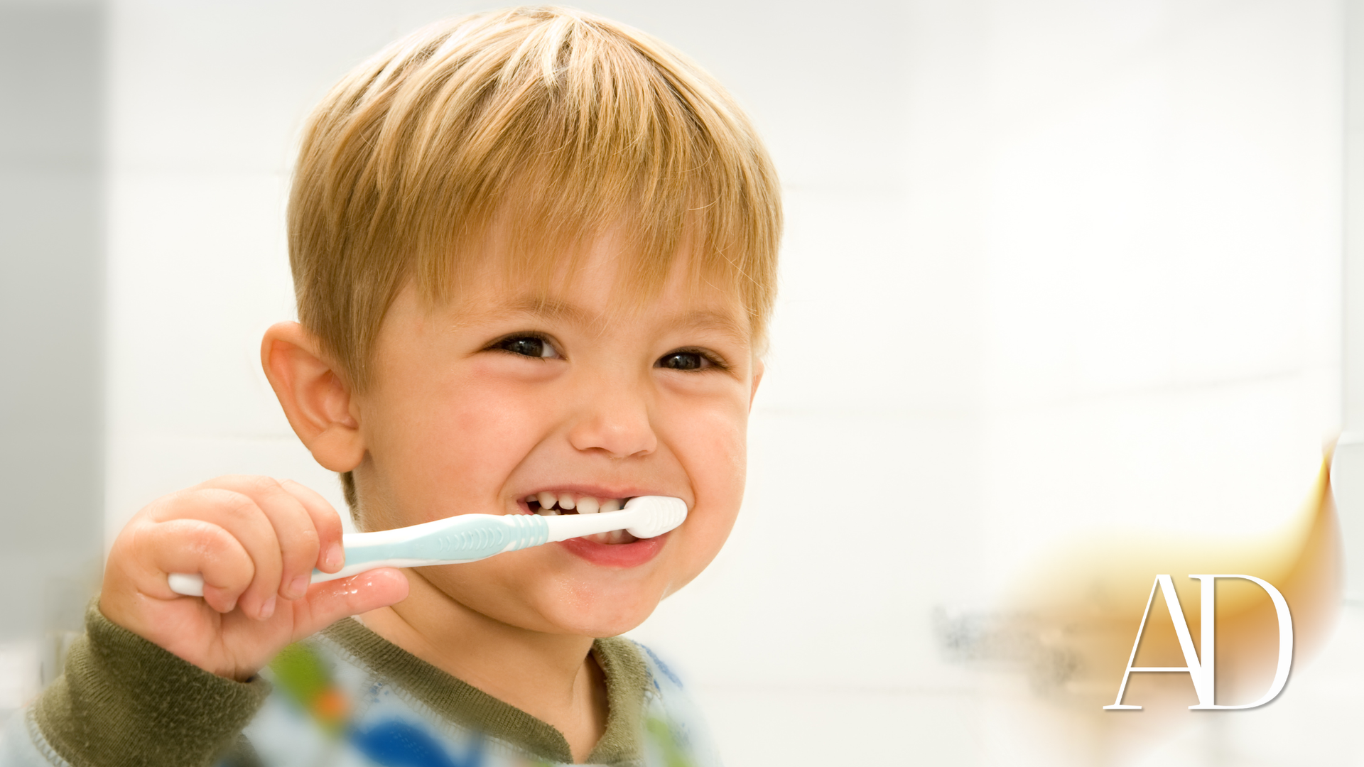Young child brushing teeth in bathroom.