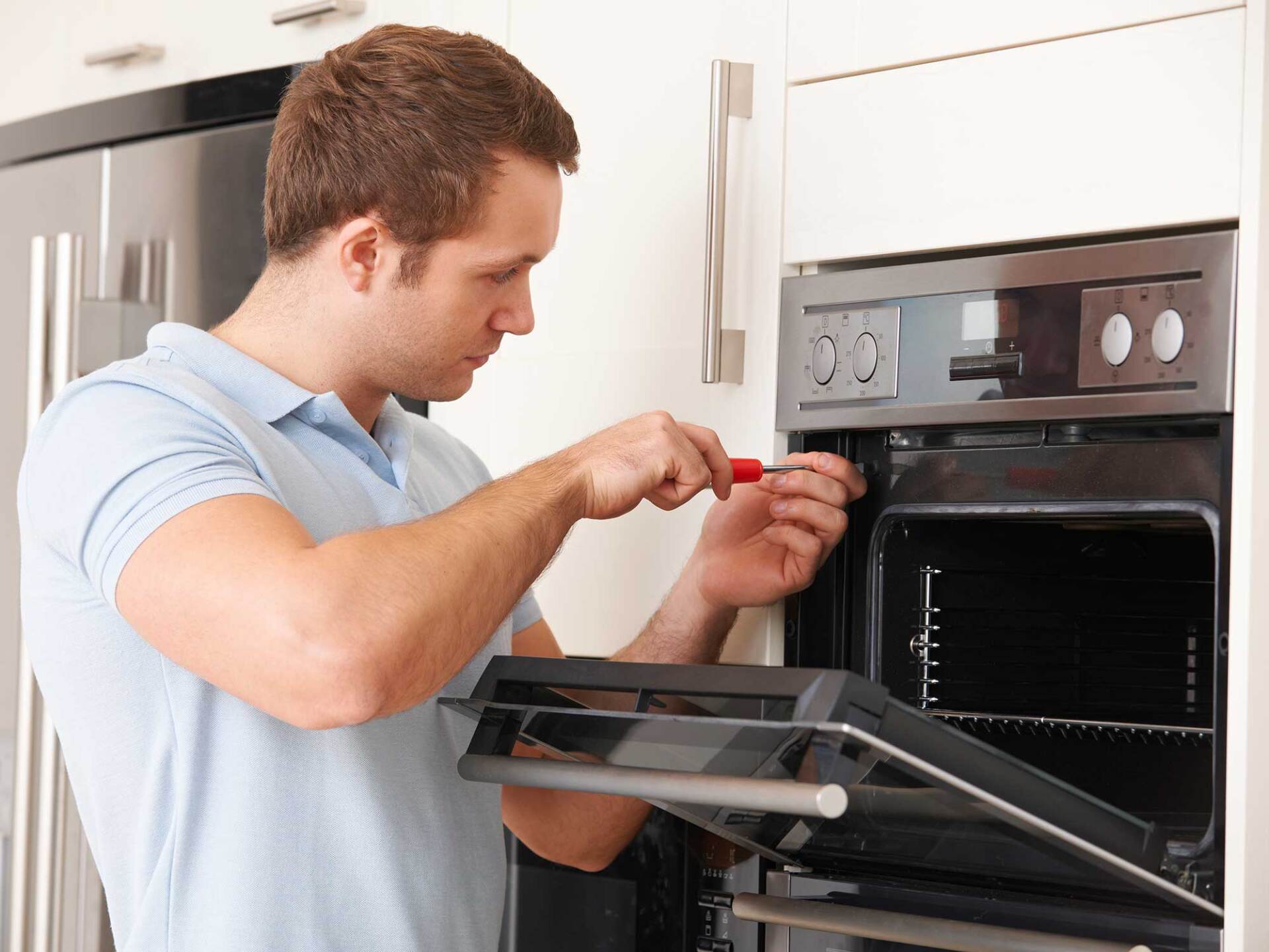Man Repairing Oven — Anchorage, AK — Refrigeration & Food Equipment Inc