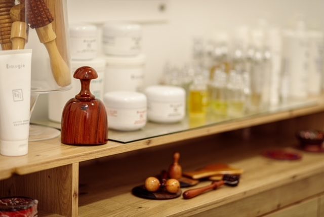 Un estante de madera con muchos cosméticos encima.