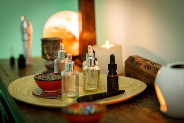 Una bandeja de aceites esenciales y velas sobre una mesa de madera.