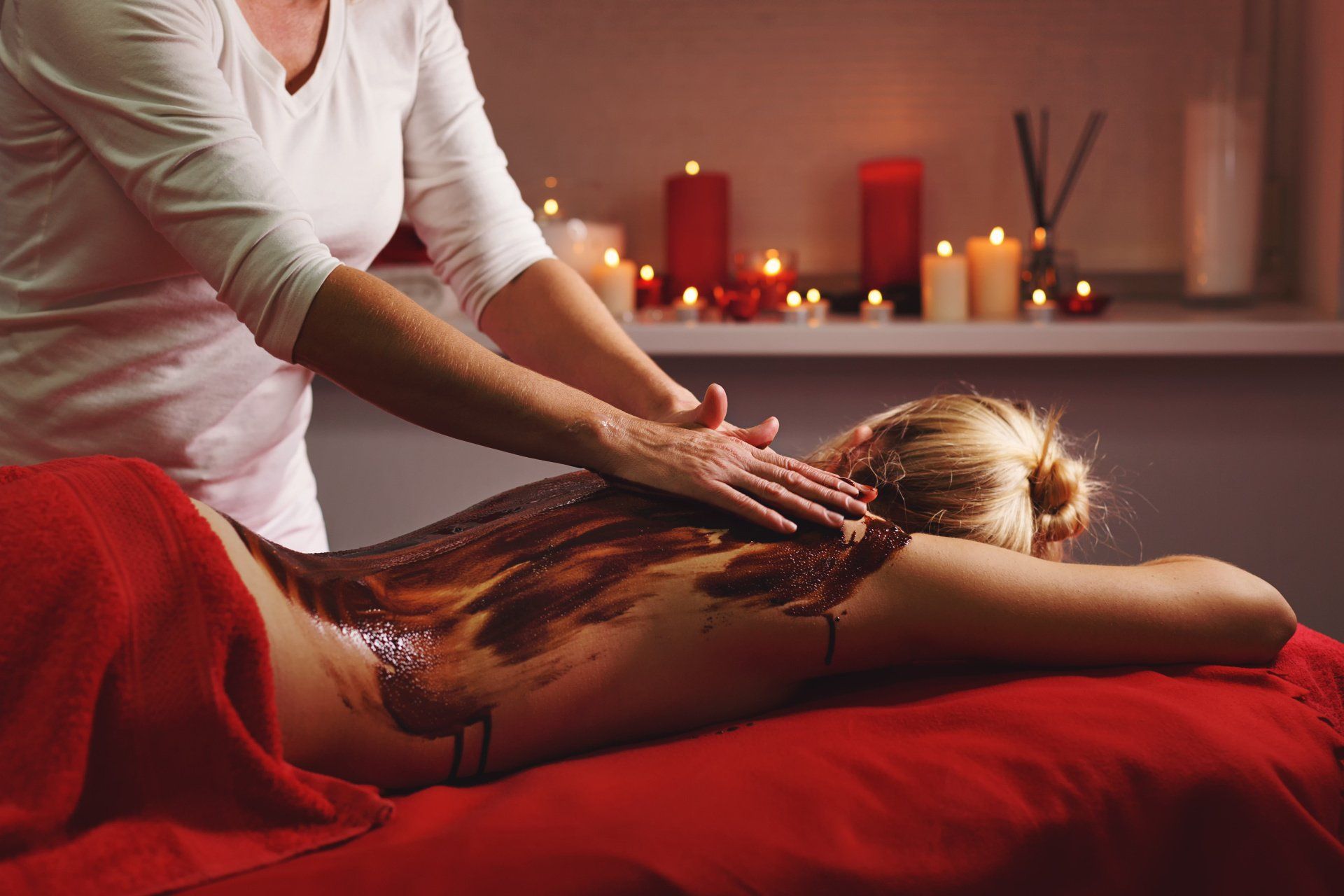 Una mujer está recibiendo un masaje de chocolate en un spa.