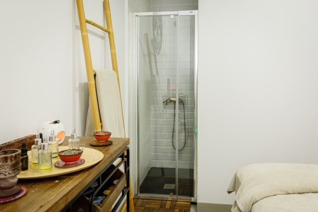 Un baño con ducha y una mesa con cuencos encima.