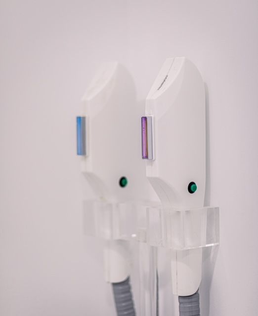 Dos máquinas de depilación blancas están colgadas en una pared.