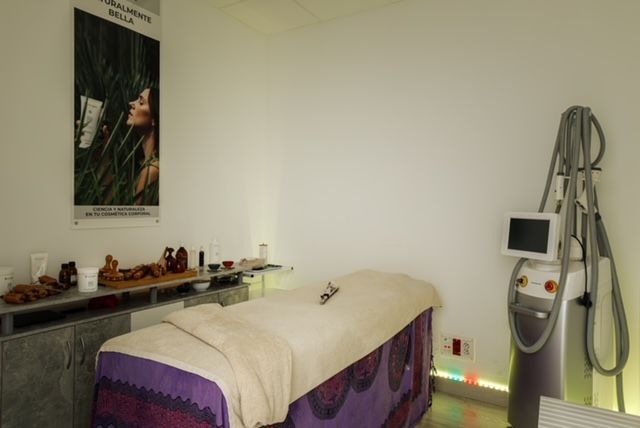 Una sala con una mesa de masajes y una máquina.