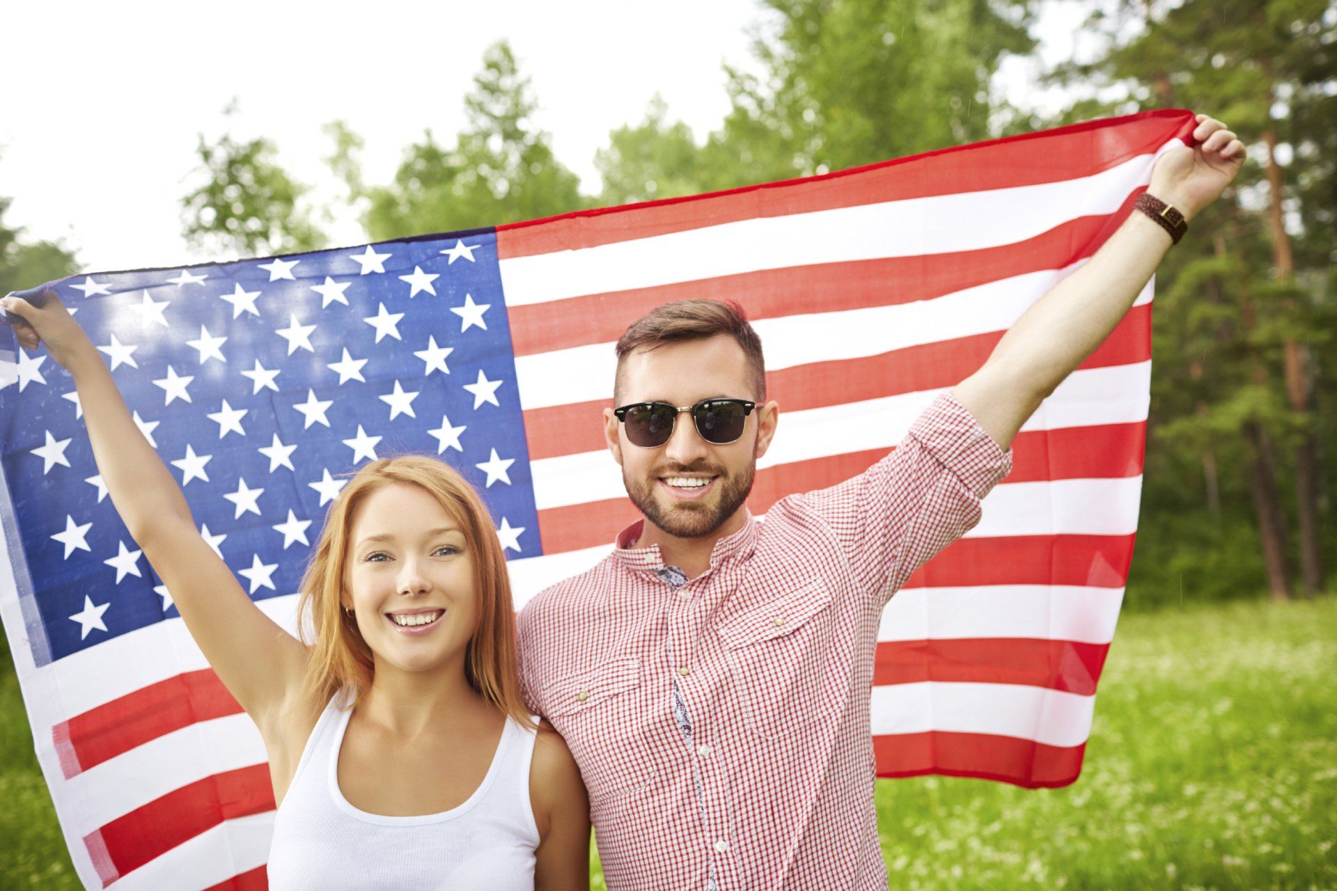 Happy man and woman holding American flag