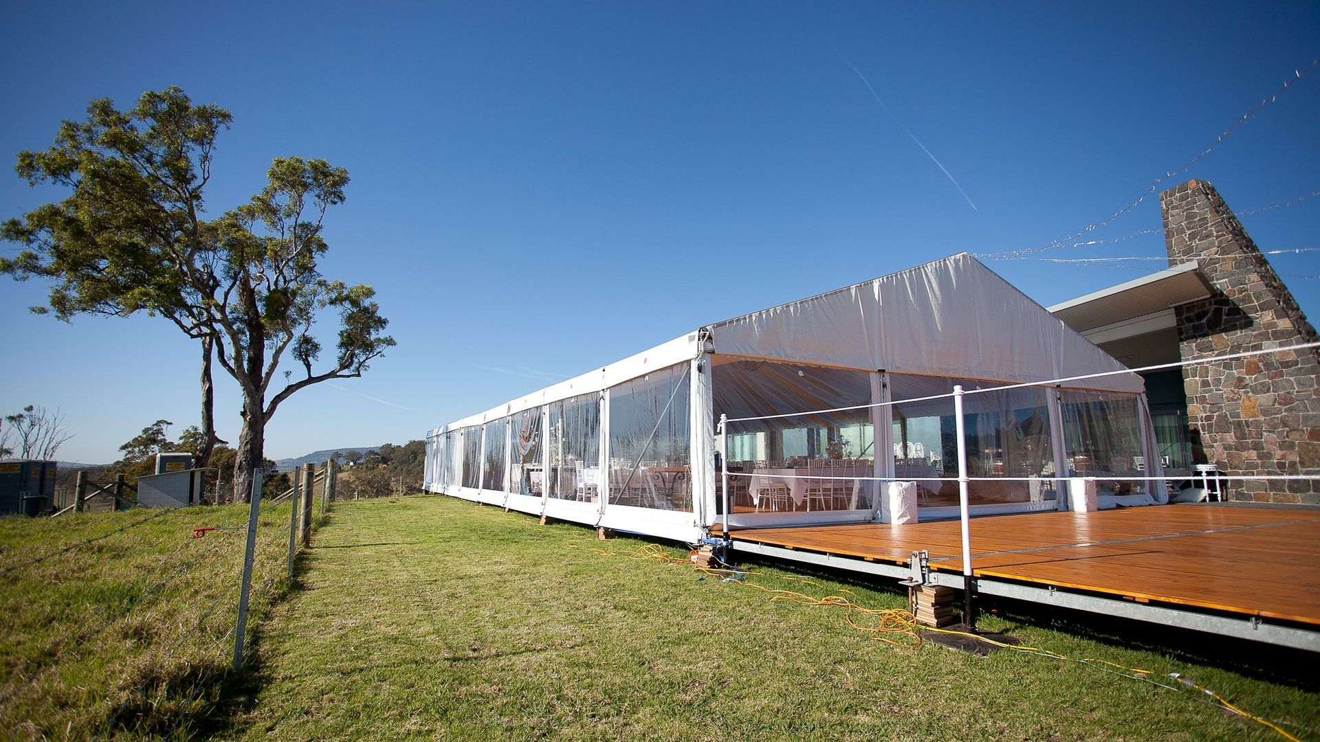 A large white tent is sitting in the middle of a grassy field.