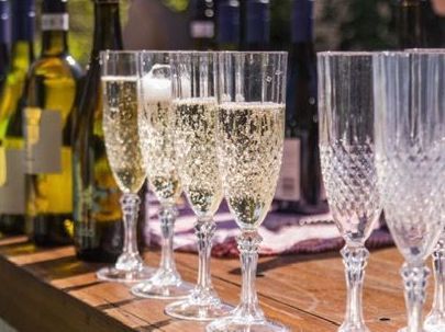 A row of champagne glasses filled with champagne on a wooden table.