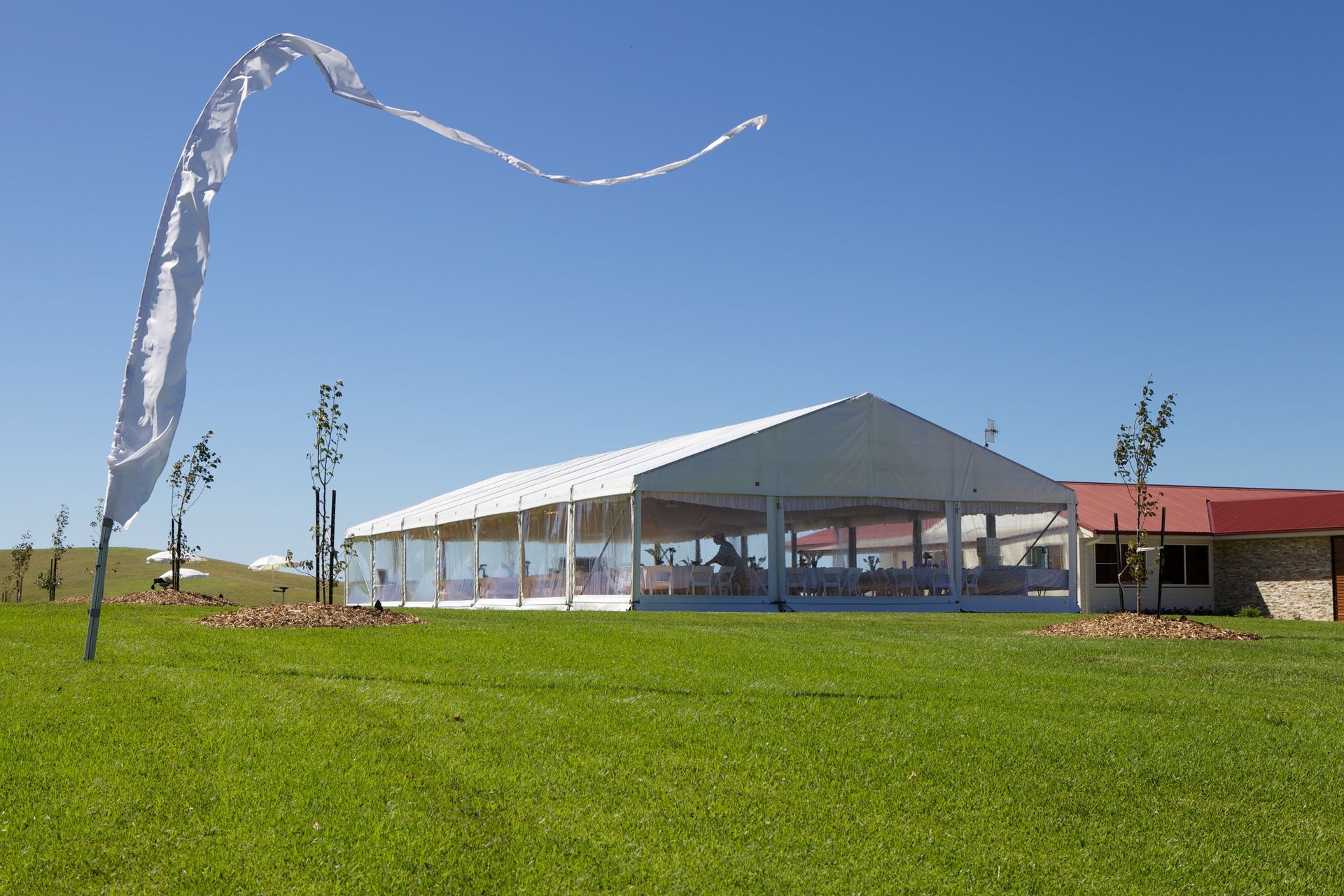 A large white tent is sitting in the middle of a grassy field.