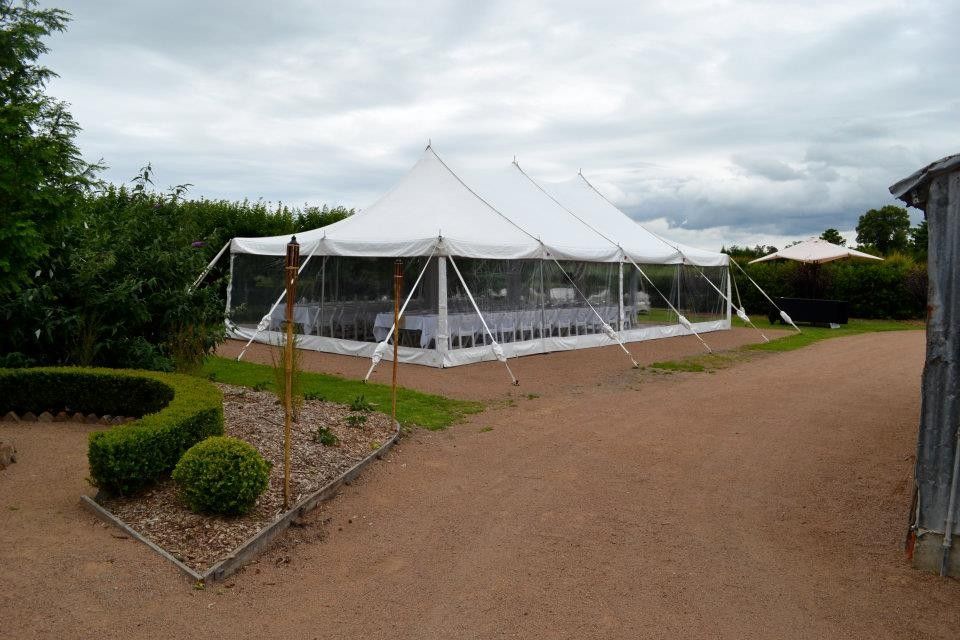 A large white tent is sitting in the middle of a dirt road.