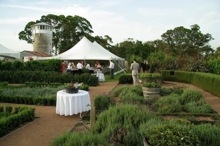 A white tent is sitting in the middle of a garden