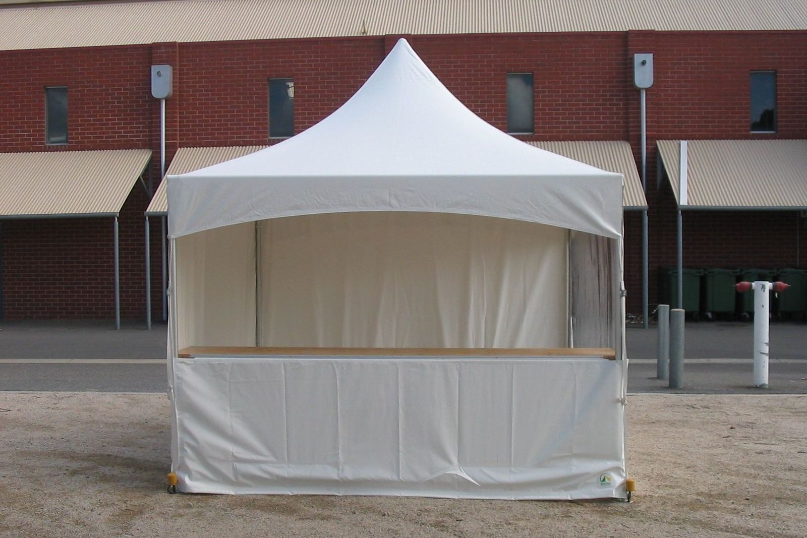 A white tent is sitting in front of a brick building