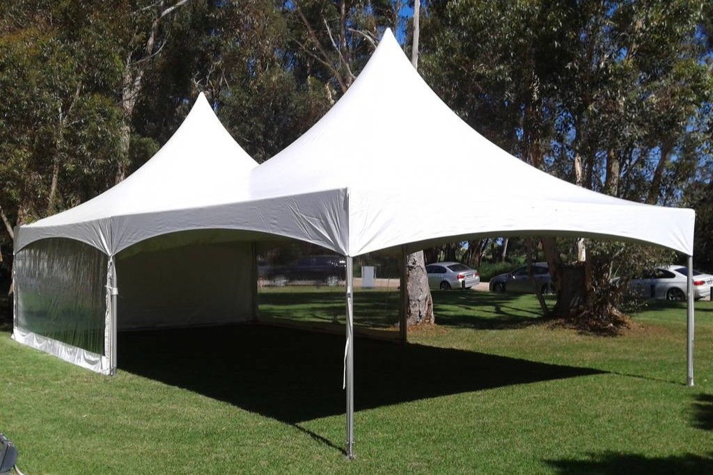 Two white tents are sitting on top of a lush green field.