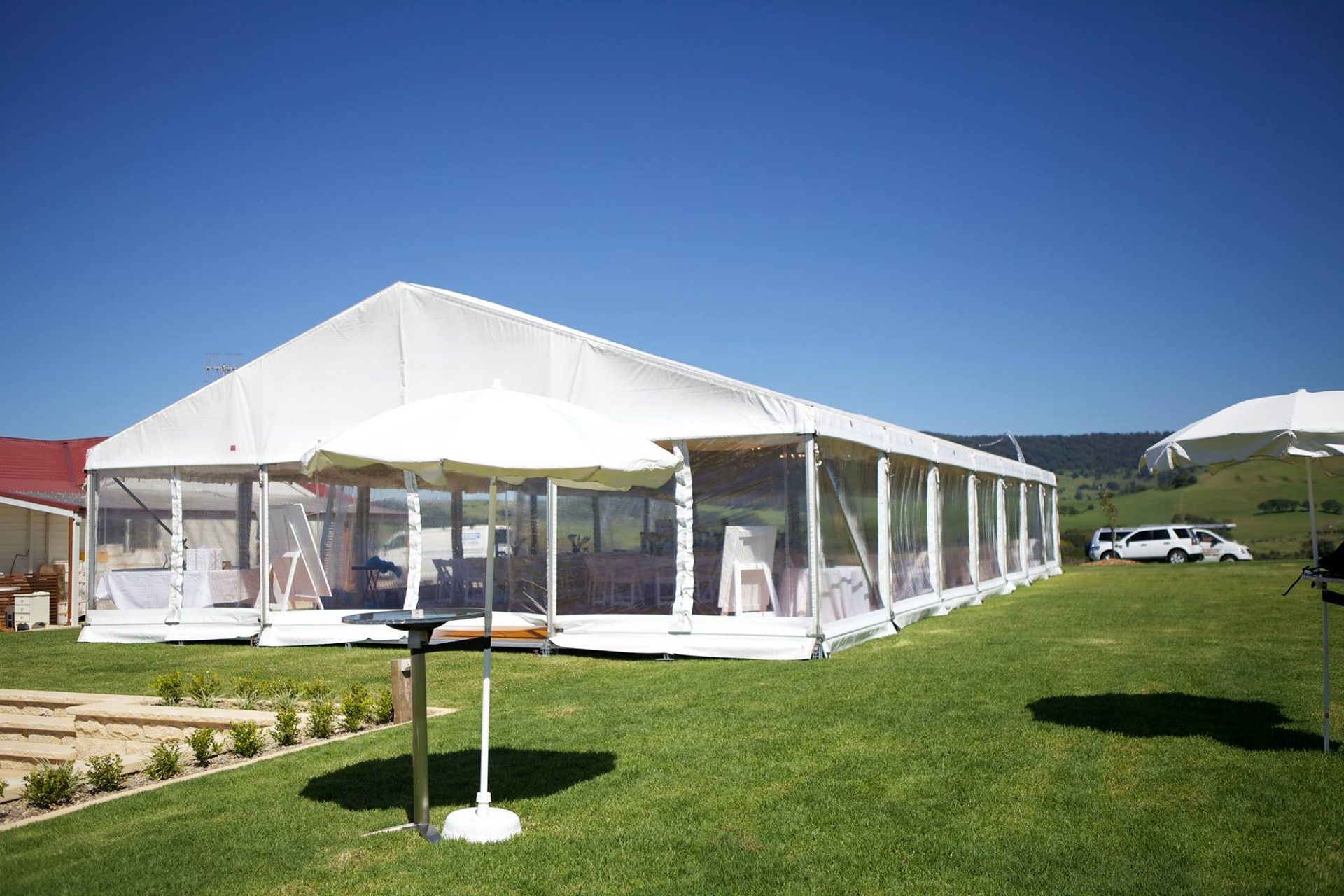 A large white tent is sitting in the middle of a grassy field.