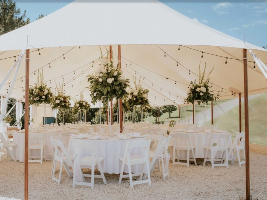 A large tent with tables and chairs underneath it