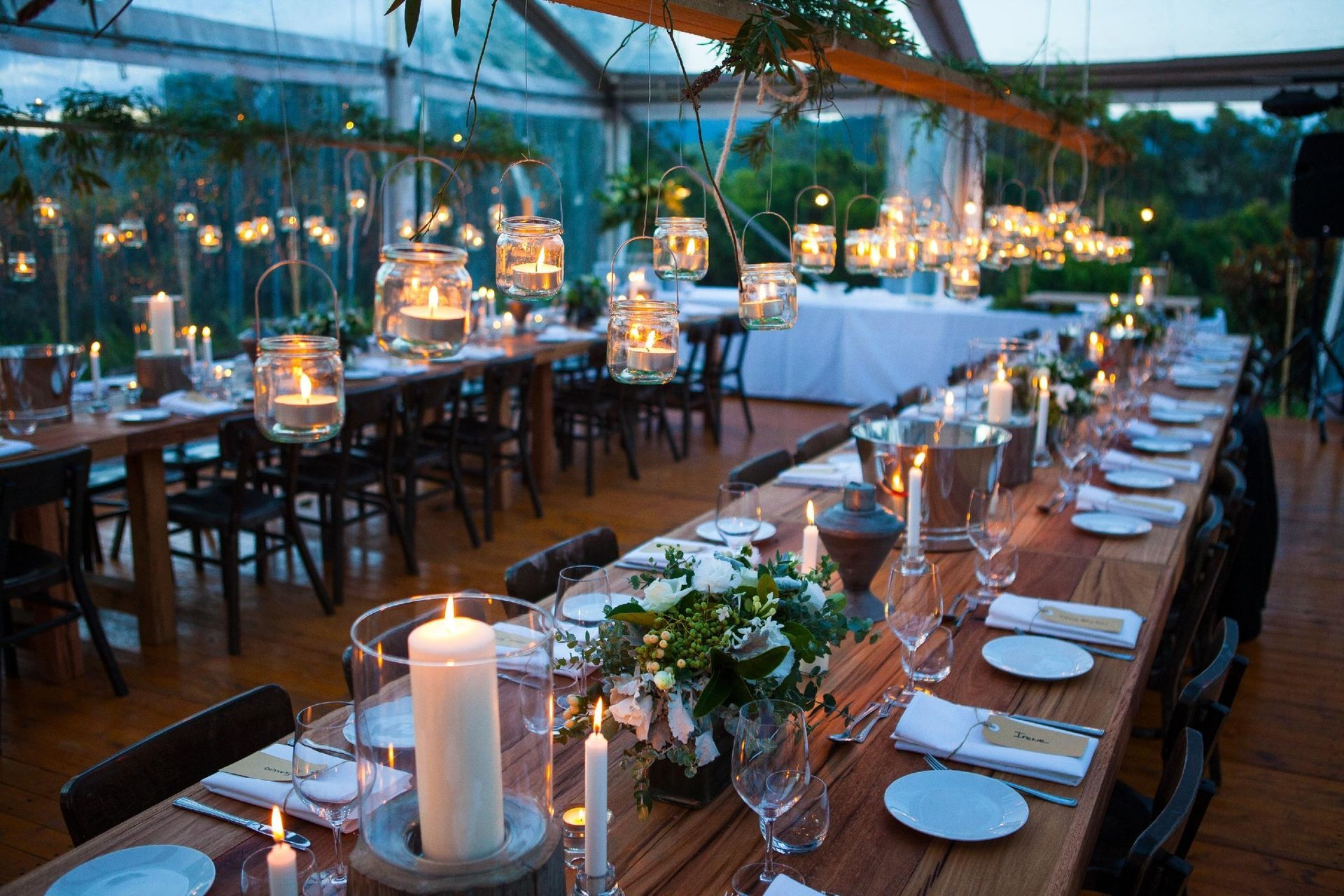 A long wooden table with candles and flowers on it.