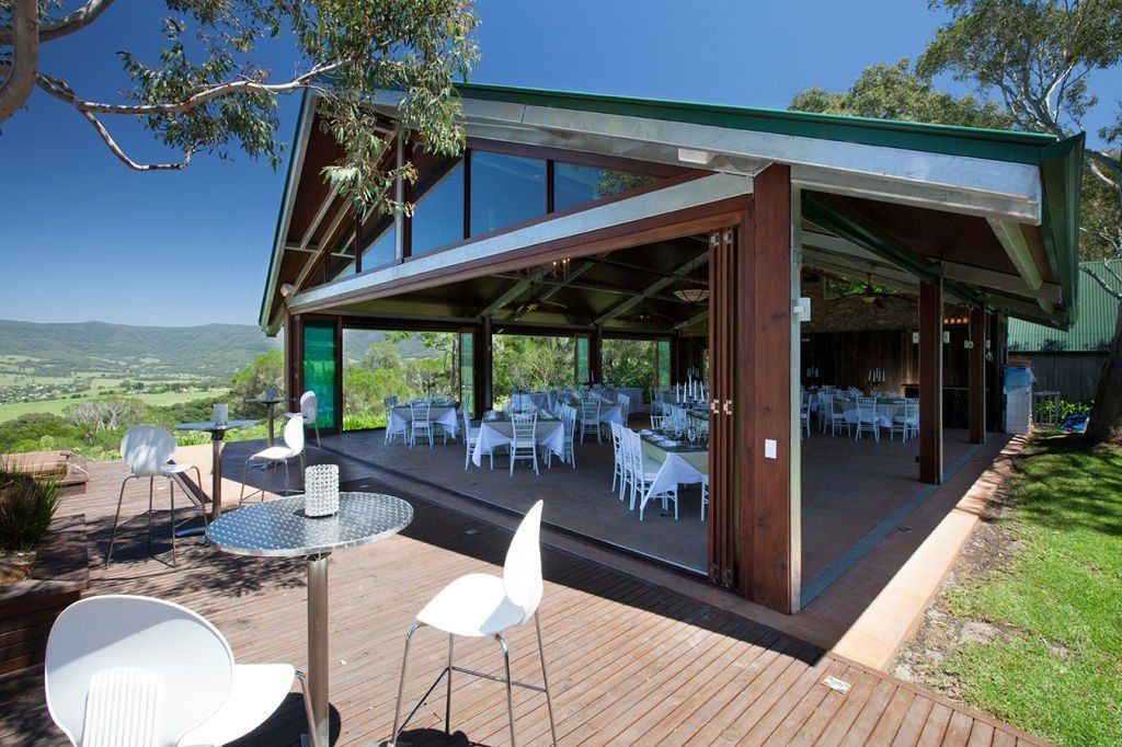 A large building with tables and chairs in front of it
