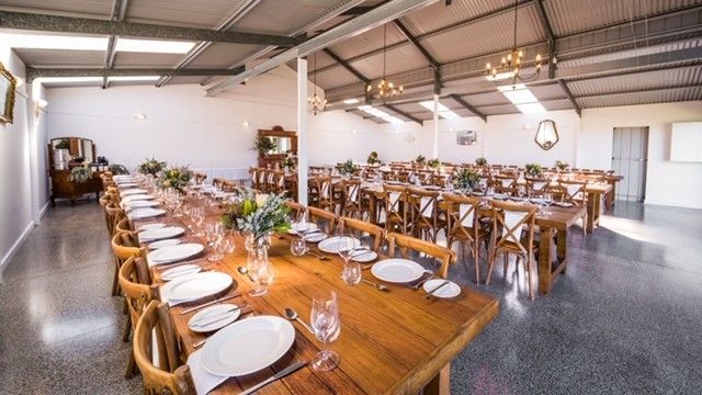 A row of wooden benches are lined up on a wooden floor.