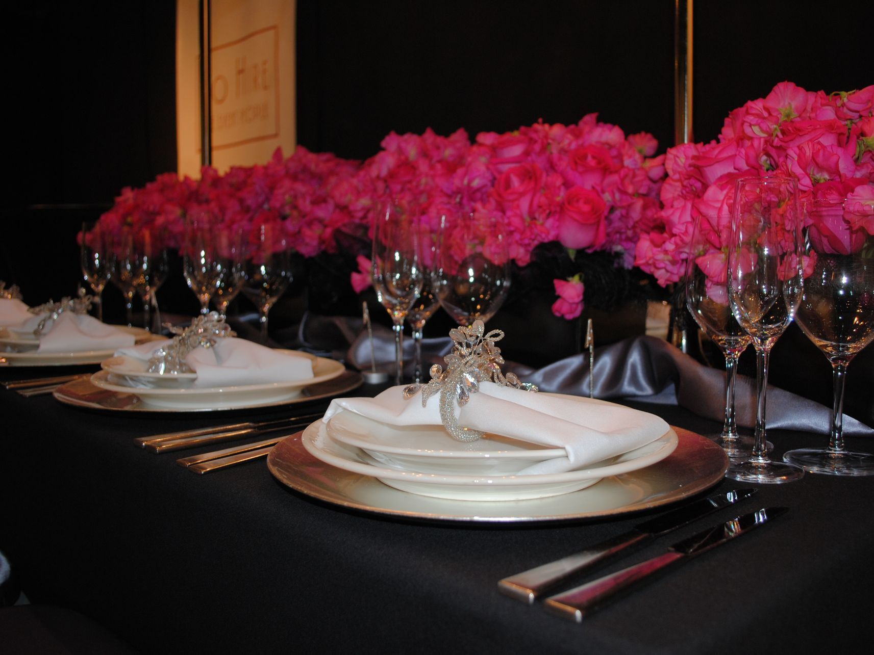 A table set with plates glasses and pink flowers