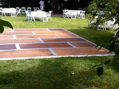 A wooden dance floor in the middle of a grassy field