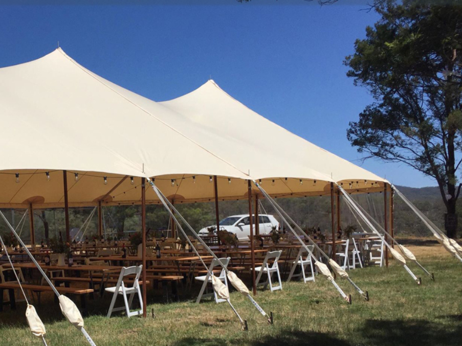 A large white tent with tables and chairs underneath it