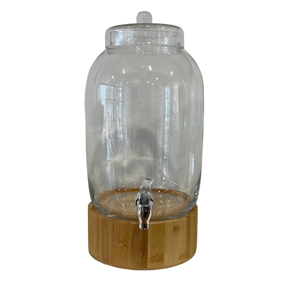 A glass beverage dispenser with a bamboo base and tap.
