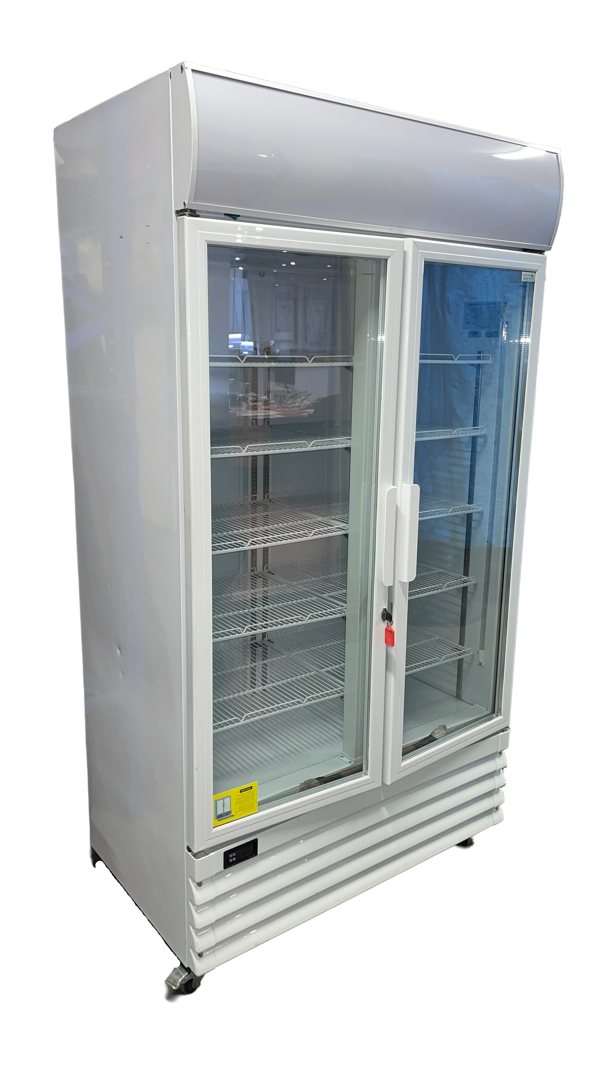 An empty refrigerator with glass doors on a white background.
