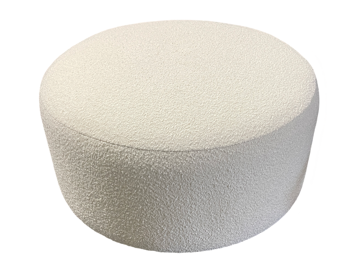 A white ottoman is sitting on a white surface.