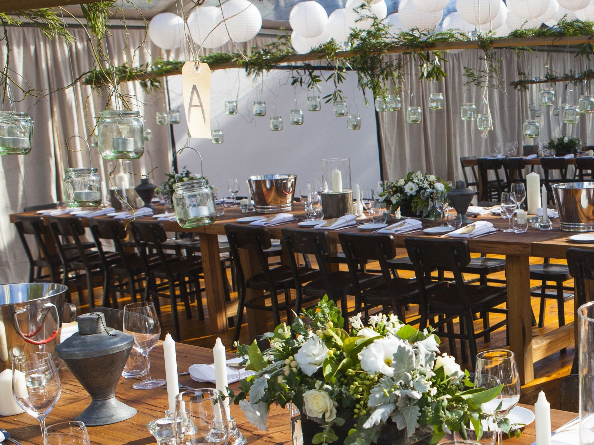 A long wooden table with candles and flowers on it
