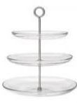 A three tiered glass cake stand with a metal handle on a white background.