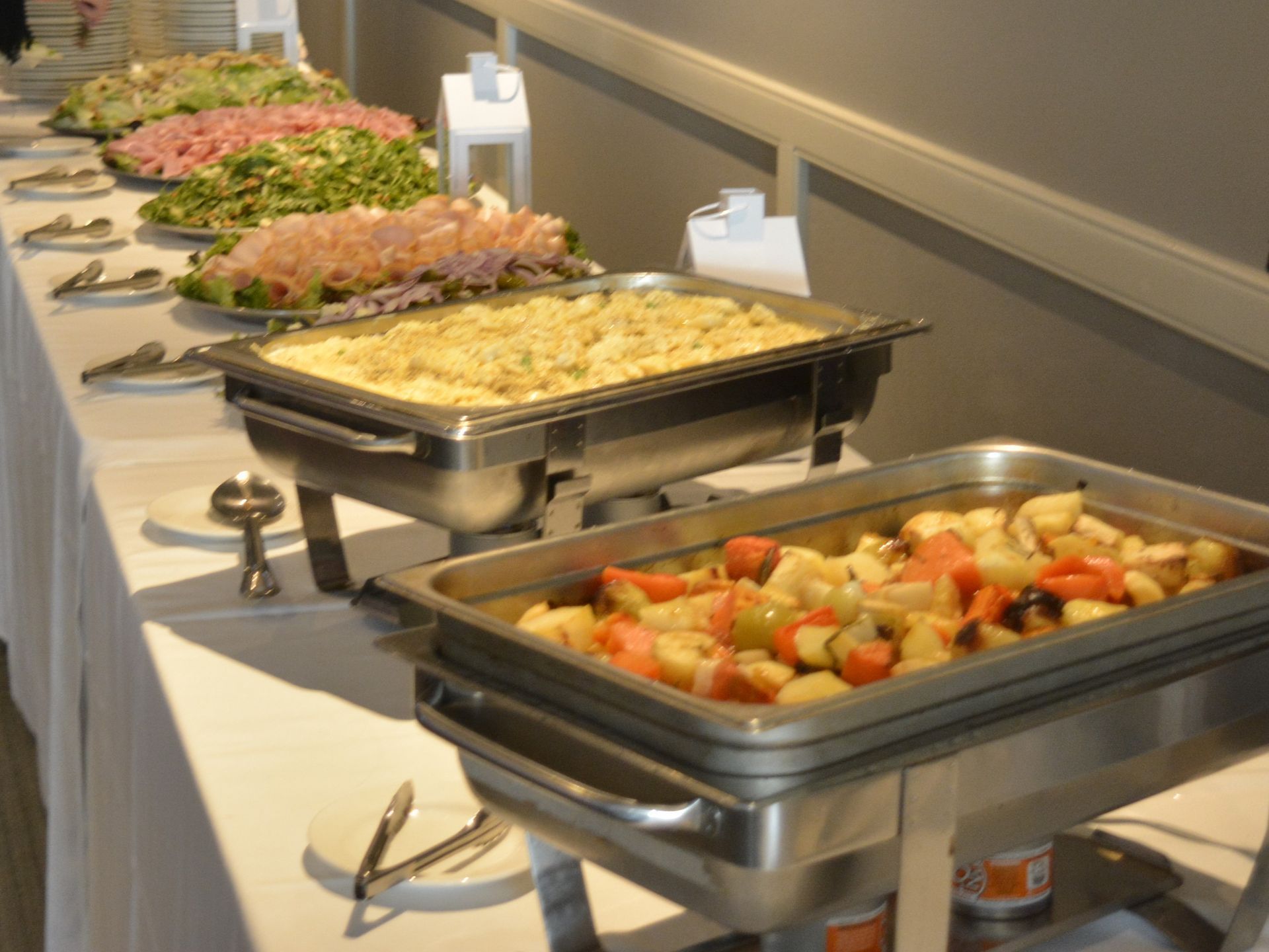 Several trays of food are lined up on a table